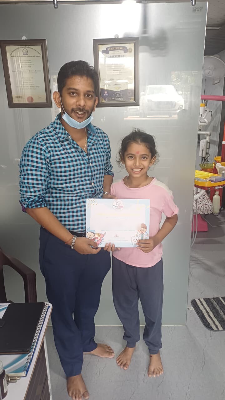 Dr. Rangan Ghosh presenting a Tiny Tooth Dental bravery certificate to a young patient in Lucknow