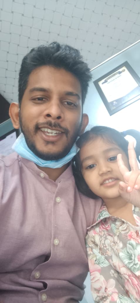 Dr. Rangan Ghosh with a smiling toddler making a peace sign after her first dental visit in Lucknow